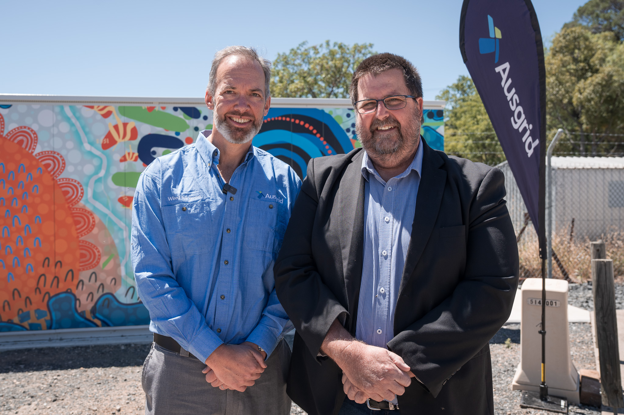 Ausgrid CEO Marc England and Merriwa business owner in front of the microgrid.