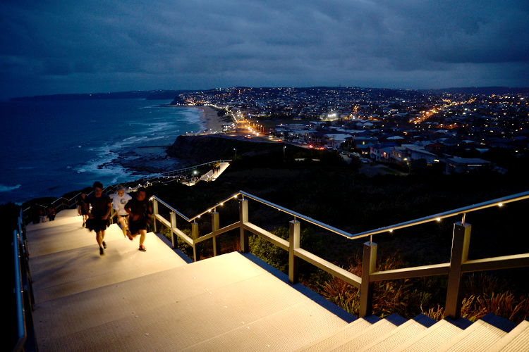 people walking near the water at night